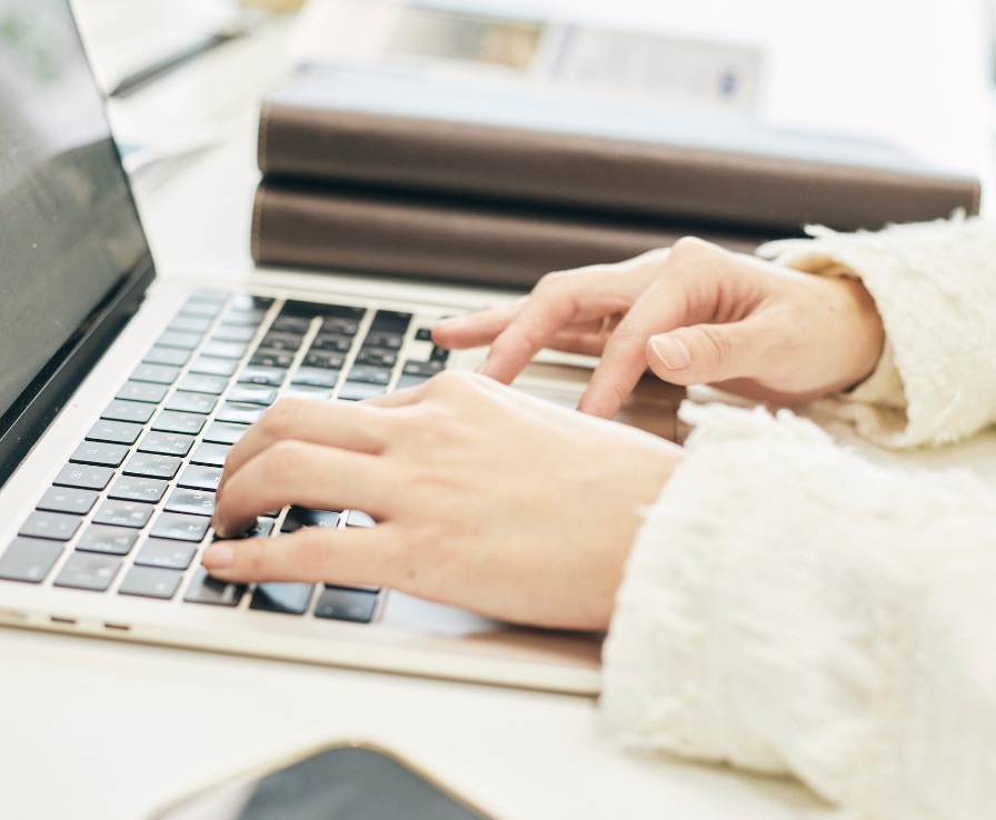 PCのキーボードをタイピングするイーエムラボのエージェントの手